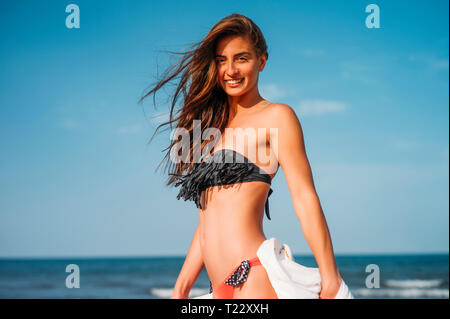 Portrait of smiling young woman wearing bikini sur la plage Banque D'Images