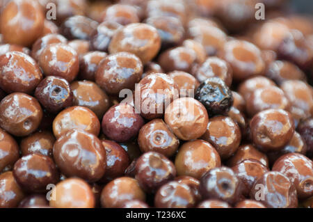 Olives noires marinées sur un étal de marché. Focus sélectif situé dans le centre. Banque D'Images
