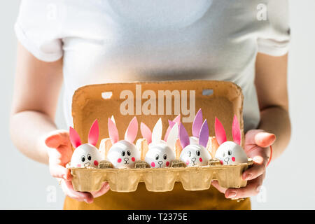 Portrait de femme tenant le bac avec des oeufs Les oeufs de poule avec lapin dessiné des visages et des oreilles papier isolated on white Banque D'Images