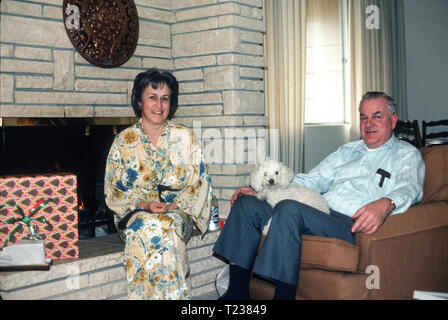 Couple d'âge moyen et leur chien se détendent dans le salon, USA 1970s Banque D'Images