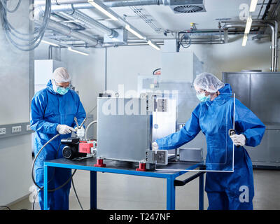 Les chimistes travaillant en salle blanche de laboratoire industriel Banque D'Images