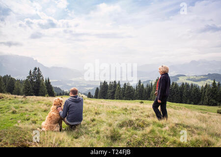 Autriche, Tyrol, Kaiser, mère et fils adulte avec chien en randonnée dans les montagnes Banque D'Images