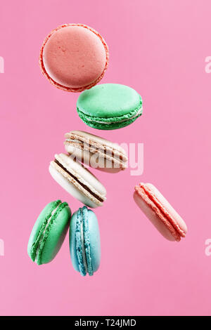 Macarons colorés traditionnels français sur fond rose. Banque D'Images