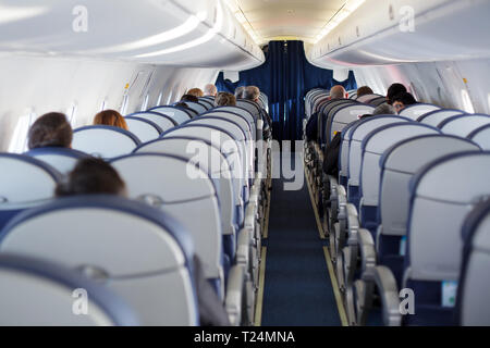 Avion à moitié vide avec peu de passagers. Passagers à l'intérieur de la cabine d'un avion en vol. Banque D'Images