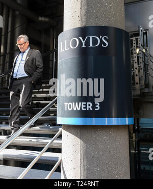 Un homme d'affaires laissant le Lloyd's Building, conçu par Richard Rogers, au Lime Street, dans la ville de London, UK Banque D'Images