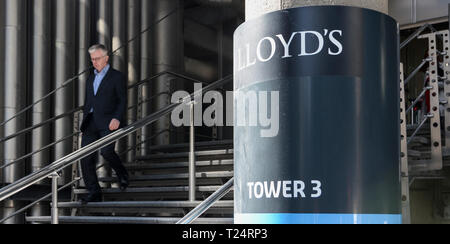 Un homme d'affaires laissant le Lloyd's Building, conçu par Richard Rogers, au Lime Street, dans la ville de London, UK Banque D'Images