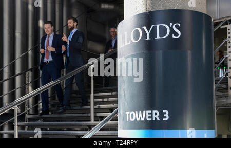 Hommes d'laissant le Lloyd's Building, conçu par Richard Rogers, au Lime Street, dans la ville de London, UK Banque D'Images