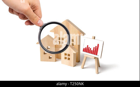 Loupe à la recherche à la maisons en bois avec un support d'image et d'informations. Demande croissante de logements et l'immobilier. La coopération d'investissements. Banque D'Images