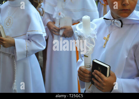 Poznan - Pologne / 22 mai 2016 Les enfants habillés en blanc alba vêtements avec livres de prière et les bougies sont en attente de la Première Communion Banque D'Images
