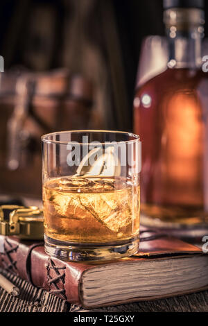 Whisky avec de la glace sur l'or vieux journal Banque D'Images