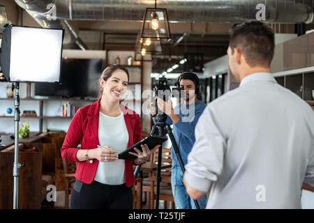 Portrait de l'entreprise au cours d'entretien avec femme journaliste. Manager répondant à la question dans le bureau. Jeune femme au travail comme reporter pour affaires Banque D'Images