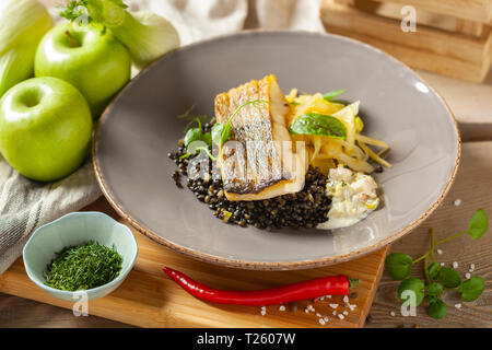 Le merlu marinés dans l'huile de citron avec lentilles noir avec du chili et le céleri, sauce écrevisses Banque D'Images