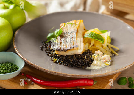 Le merlu marinés dans l'huile de citron avec lentilles noir avec du chili et le céleri, sauce écrevisses Banque D'Images