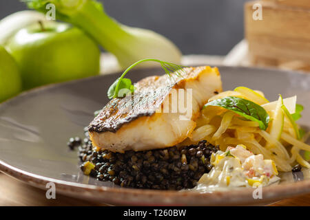 Le merlu marinés dans l'huile de citron avec lentilles noir avec du chili et le céleri, sauce écrevisses Banque D'Images