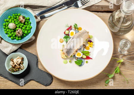 Le hareng fumé, crème aigre, oignons marinés au vinaigre d'échalote et sirop d'shimej marinés, salade de légumes, champignons, oeuf de caille, ciboulette mayonnais Banque D'Images