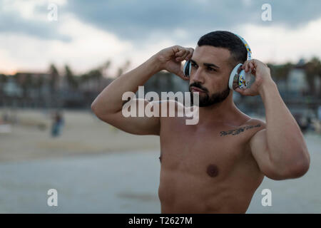 Portrait of Mid adult man musclé avec des écouteurs à l'extérieur Banque D'Images