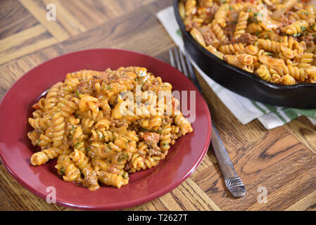 Une assiette de pâtes rotini avec goulasch servi à partir d'un poêle en fonte Banque D'Images