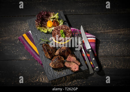 Steak de kangourou avec un riz rouge et mangue sur la plaque d'ardoise Banque D'Images