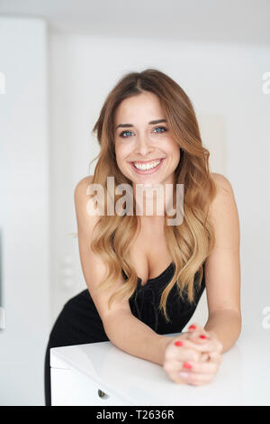 Portrait of happy young woman wearing black dress Banque D'Images