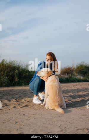 Allemagne, Hambourg, femme avec chien sur la plage au bord de l'Elbe Banque D'Images