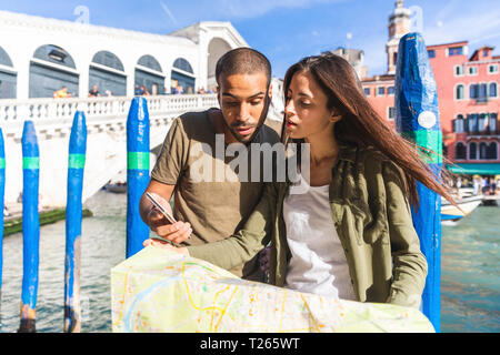 L'Italie, Venise, couple looking at map avec le pont du Rialto en arrière-plan Banque D'Images