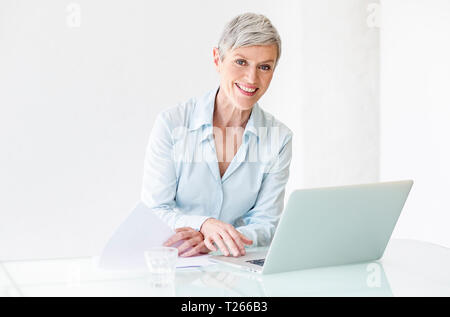 Portrait of smiling mature woman working on laptop Banque D'Images