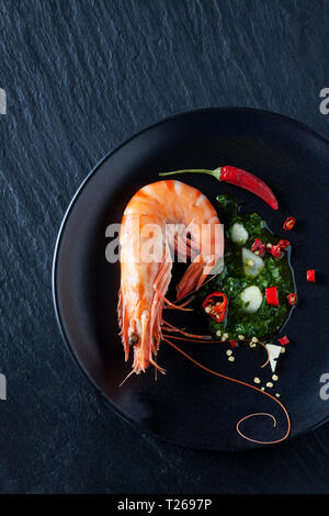 Hernbs avec crevette, le piment et l'ail sur la plaque noire Banque D'Images