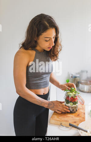 Woman preparing salad d'aller sur planche à découper Banque D'Images