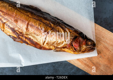 Poissons truite fumée sur fond sombre Banque D'Images