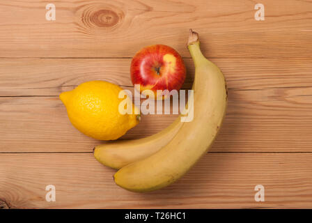 Apple et la banane citron sur un fond de bois. Vue du dessus . Banque D'Images