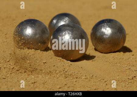 Une boule français capturé au moment de l'impact, causant une petite explosion de sable Banque D'Images