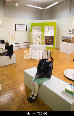 Vue intérieure d'Rochdales Pierres museum and art gallery. Enfants / kids / enfant assis et profiter de l'exposition. Rochdale, Lancashire. England UK. (106) Banque D'Images