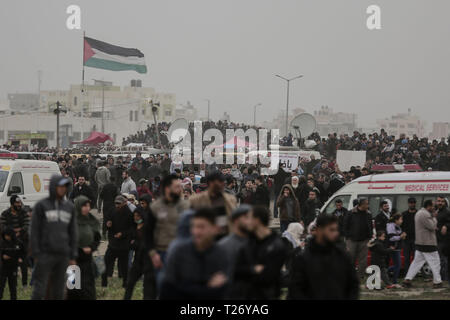 La ville de Gaza, Territoires palestiniens. 30Th Mar, 2019. Des manifestants palestiniens vague des drapeaux palestiniens comme ils marche vers la frontière Israel-Gaza, sur le premier anniversaire de la grande marche du retour des protestations. Credit : Mohammed Talatene/dpa/Alamy Live News Banque D'Images