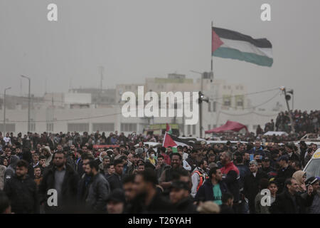 La ville de Gaza, Territoires palestiniens. 30Th Mar, 2019. Des manifestants palestiniens vague des drapeaux palestiniens comme ils marche vers la frontière Israel-Gaza, sur le premier anniversaire de la grande marche du retour des protestations. Credit : Mohammed Talatene/dpa/Alamy Live News Banque D'Images