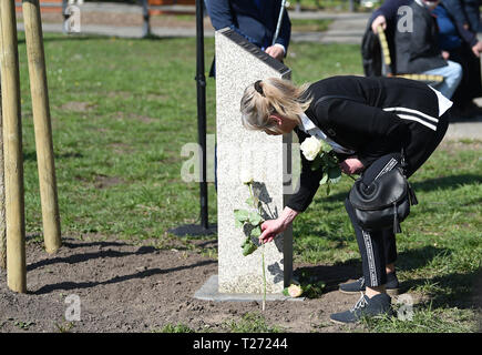 Brême, Allemagne. 30Th Mar, 2019. Des proches de victimes de l'Gladbeck en otage drame jeter à la stèle commémorative roses après l'inauguration d'un lieu de commémoration des victimes de l'Gladbeck d'otages. Le 16 août 1988, deux hommes ont pris des otages à Gladbeck (Rhénanie du Nord-Westphalie), puis s'enfuit à travers l'Allemagne. Le 17 août 1988 ils ont détourné un bus dans la Huckelriede district. Credit : Carmen Jaspersen/dpa/Alamy Live News Banque D'Images