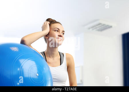 Un jeune instructeur de conditionnement physique avec une boule d'exercice. Banque D'Images