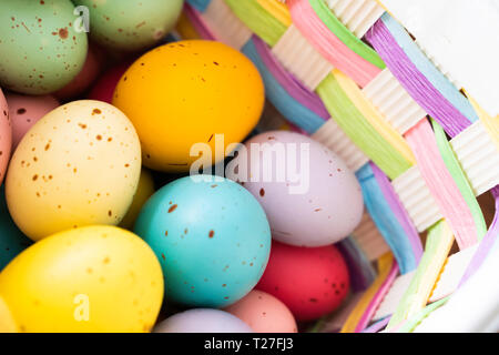 Les oeufs de Pâques peints aux couleurs vives en panier Banque D'Images