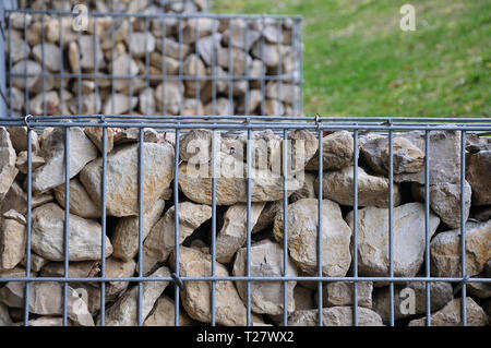 Close-up de cage en métal rempli de moellons de calcaire vallonné dans le parc public Banque D'Images