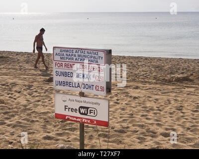 Signe de l'information, transats et parasols à louer om la plage dans la destination de vacances Ayia Napa Chypre, connexion Wi-Fi gratuite offerte par la municipalité Banque D'Images