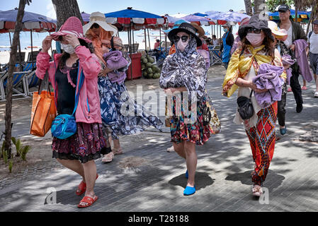 Masques de visage. Les femmes portent des masques, des châles et des chapeaux pour se protéger contre le soleil chaud. Pattaya, Thaïlande, Asie du Sud-est Banque D'Images