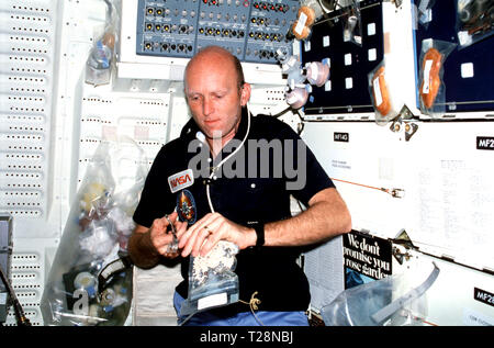 M003-26-253 (30 mars 1982) --- Pilote C. Gordon Fullerton, le port de kit de communication (assy) casque (mini-HDST), prépare des repas sur compartiment intermédiaire. Clips de Fullerton (céréales alimentaires déshydratées) forfait avec des ciseaux. L'ouverture permettra à Fullerton pour insérer JSC kit canon à eau distributeur d'eau pour chauffer matières avec de l'eau chaude. Plateau à repas ensemble est fixé à l'avant compartiment intermédiaire locker et détient plus d'emballages d'aliments et les contenants de boisson. Banque D'Images