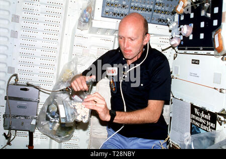 (30 mars 1982) --- Pilote Fullerton, le port de kit de communication (assy) casque (mini-HDST), d'insérer le kit de distributeur d'eau JSC canon à eau en plastique pour aliments déshydratées (céréales) forfait pour le remplir avec de l'eau chaude. Banque D'Images