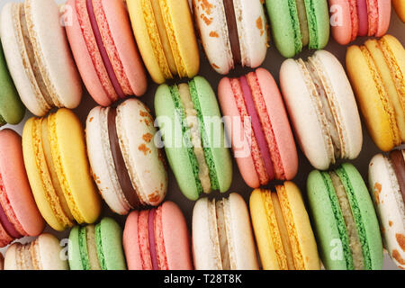 Rangées de macarons français colorés. Arrière-plan créatif. Vue d'en haut. Banque D'Images