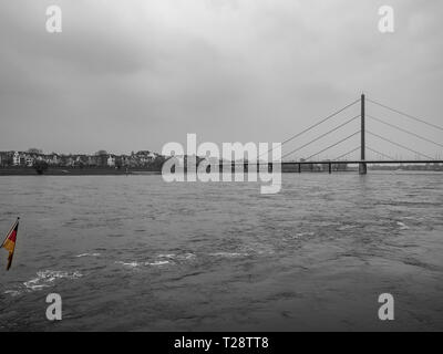 Düsseldorf, Allemagne, 23 mars 2019. Suspension moderniste pont sur le Rhin avec drapeau allemand au premier plan et résidentiel aux Banque D'Images