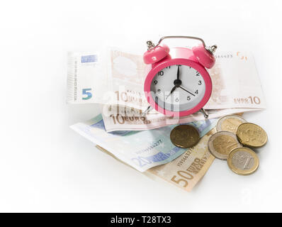 Réveil vert sur l'arrière-plan de l'euro et les pièces en euros. Isolé sur fond blanc. Concept - le temps est argent. Banque D'Images