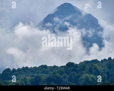 La haute montagne avec des pistes vertes cachées dans d'épais nuages et le brouillard. Pyramide noir, montagne, SOCHI Krasnaya Polyana, Caucase, Russie. Banque D'Images