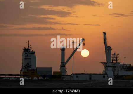 Grue de levage montés sur un cargo pendant le coucher du soleil Banque D'Images