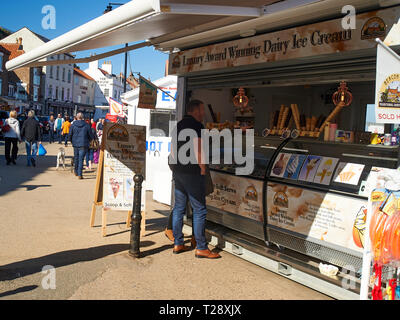 Les gens qui achètent des aliments de rue à partir de la cale donnant sur le port de Whitby, North Yorkshire Coast, England, UK, FR. Banque D'Images