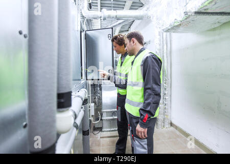 Deux ingénieurs travaillant sur le contrôle de l'état de commutation de l'énergie électrique le poste de distribution