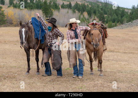 Deux cowgirls se placer à côté de leurs chevaux dans le Wyoming Banque D'Images